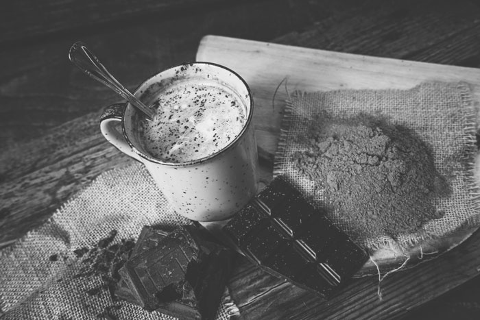 mug with hot cocoa displayed with chocolate bar and chocolate powder