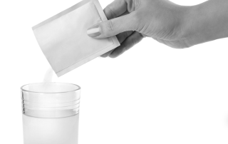 closeup of woman pouring medical powders into liquid